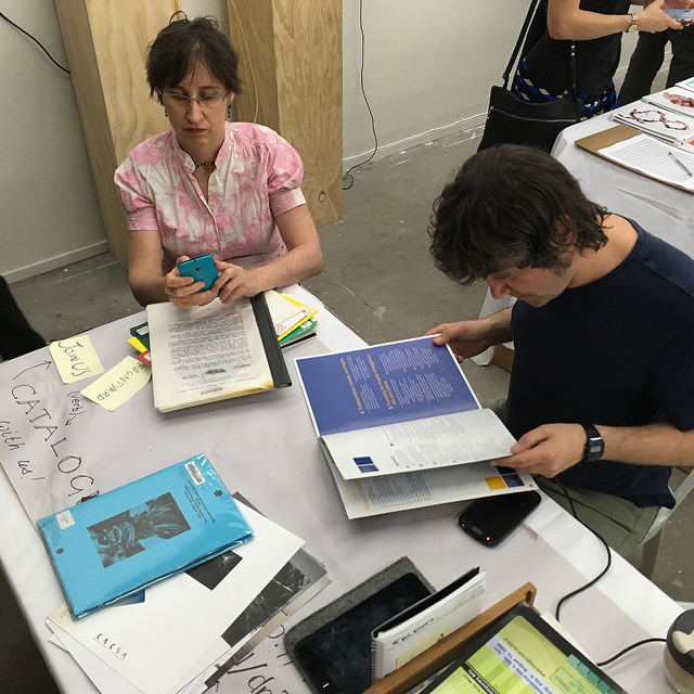 Photograph of people cataloguing books at the Frontyard table, Volume 2017 Book Fair