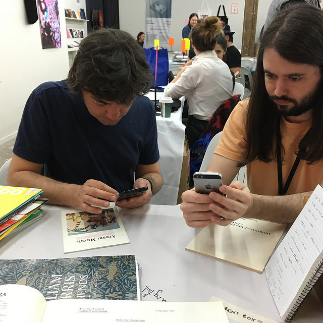 Photograph of people cataloguing books at the Frontyard table, Volume 2017 Book Fair
